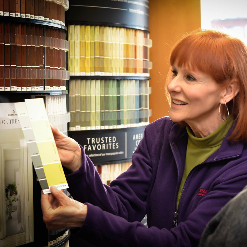 Anderson Paint Color Expert Gayle Pesek helping a customer choose paint colors at the color chip display.