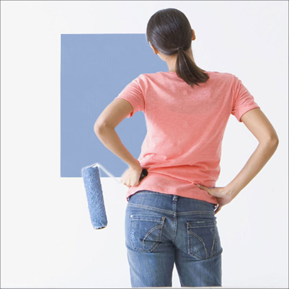 female observing a sample of a paint color on a Mighty Board tester in her room